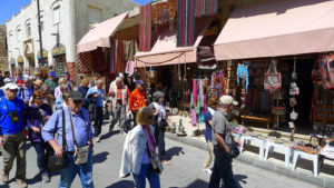 Bus-loads of visitors pack Madaba's souvenir shops. 