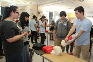 Scott Ninokawa (dcha.), estudiante de medicina de la escuela de medicina David Geffen de la Universidad de California en Los Ángeles (UCLA), instruye a estudiantes latinos de la secundaria Esteban Tores sobre cómo lograr que los bebés expulsen objetos que se les traban en la tráquea. La capacitación sirve para motivar a los estudiantes de secundaria a estudiar medicina. Conscientes de la falta de médicos hispanos bilingües para atender a pacientes latinos, estudiantes de esta escuela se han propuesto incrementar la cantidad de estudiantes de medicina para 2016. "Con la población de latinos que está creciendo todos los días es importante tener más doctores latinos que entiendan la cultura latina, que entiendan como tratar a otros pacientes latinos", dijo a Efe Orlando Gonzáles, estudiante de medicina de UCLA. "Ahora tenemos muy pocos latinos que puedan atender a esta población y estamos tratando de ayudar en eso, tratando de decirle a los estudiantes que estudien para ser doctores", agregó el futuro médico originario de México. EFE/IVAN MEJIA