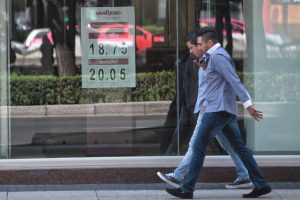 Dos hombres caminan junto a una ventanilla bancaria donde se observa el precio del dólar hoy, martes 20 de septiembre de 2016, en Ciudad de México (México). El peso mexicano se depreció hoy un 0,81 % frente al dólar estadounidense respecto a su cotización a la venta en la jornada anterior. EFE/Sáshenka Gutiérrez